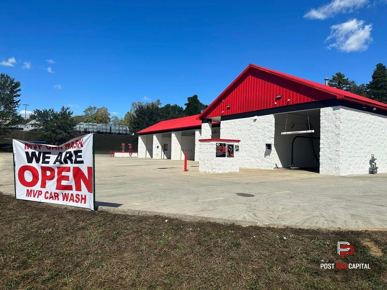 MVP Car Wash after: red roof, white stone facade, We Are Open banner